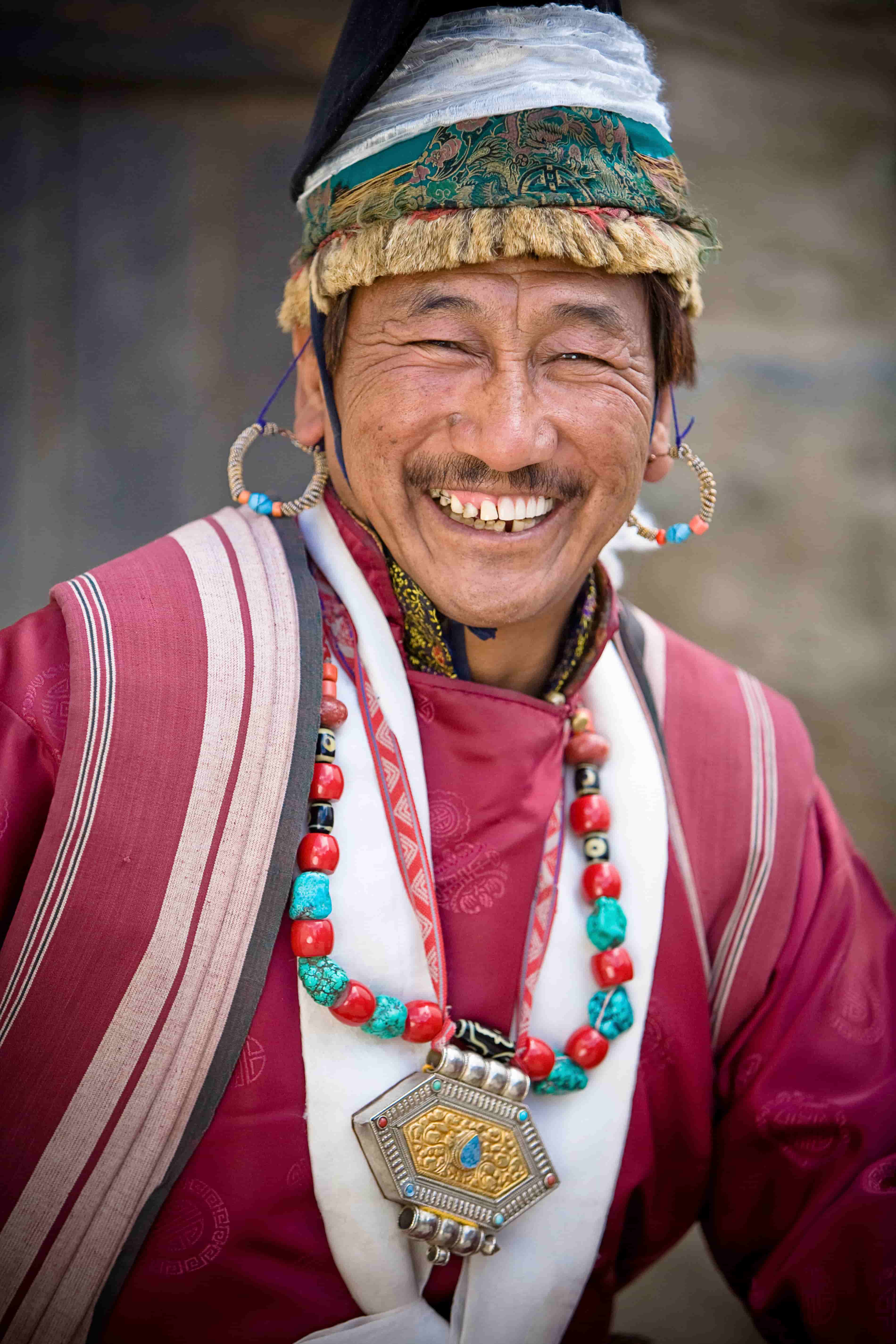 The man in traditional clothing with a smile.
