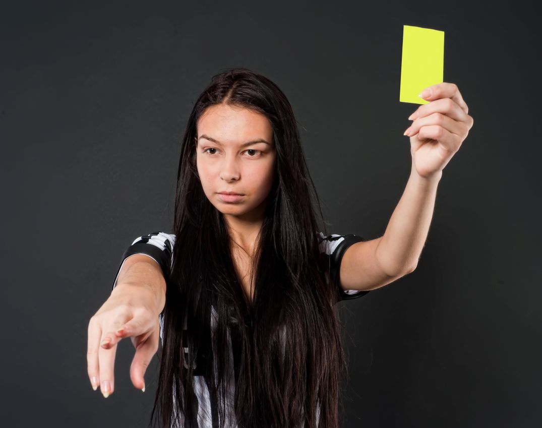 Female Soccer Referee with yellow card.