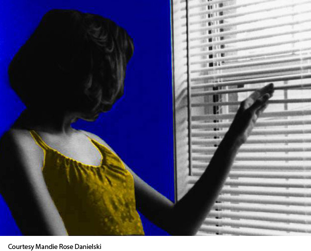 Colorized photo of a woman peeking through window blinds