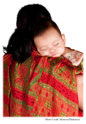 A mother holding her baby and baby is sleeping on her shoulder.