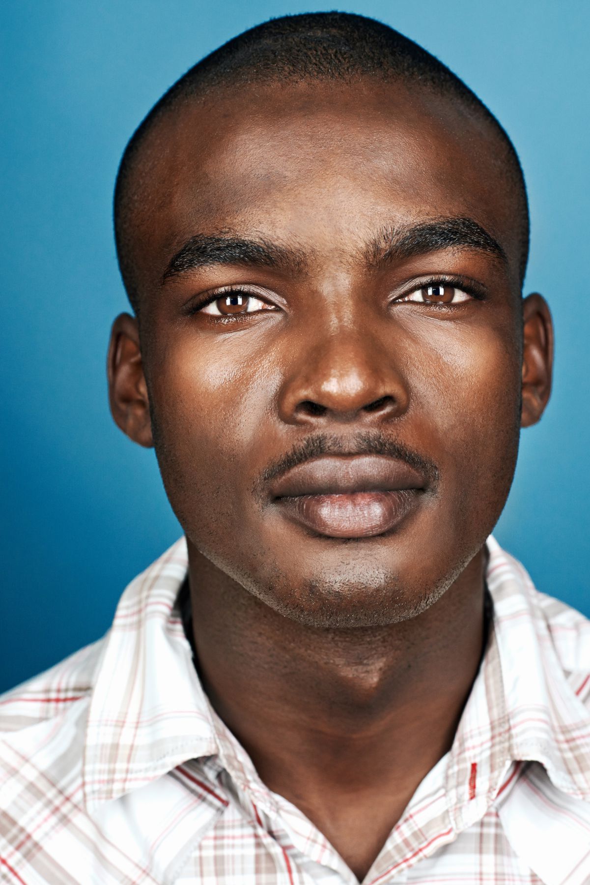 portrait of natural real african man on blue background